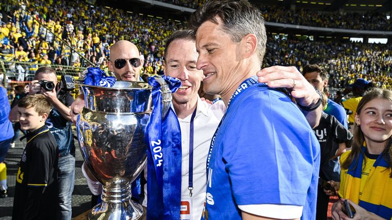 Chris O'Loughlin, director deportivo de la Unión y jefe del entrenador de Alexander Blessin, celebró con un trofeo después de ganar las finales de la Copa Belgium.