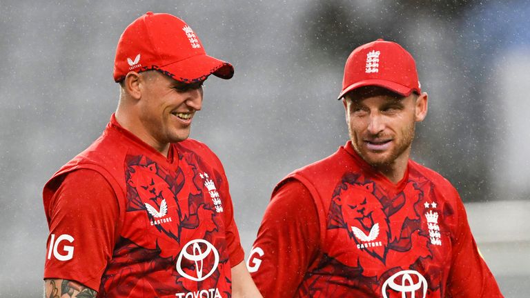 England players Brydon Carse and Jos Buttler, right, leave the field as the rain delays play during the T20 cricket international between New Zealand and England in Auckland, New Zealand, Thursday, Oct.23, 2025. (Andrew Cornaga/Photosport via AP)