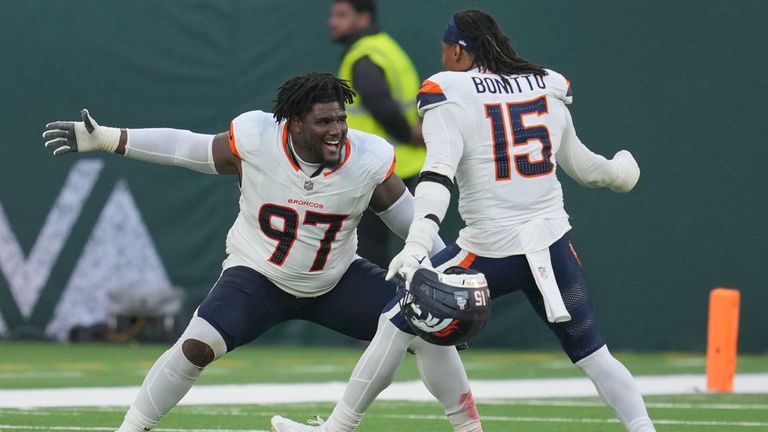 Denver Broncos defensive tackle Malcolm Roach (97) and Denver Broncos linebacker Nik Bonitto (15) celebrate after the NFL football game between the Denver Broncos and the New York Jets, Sunday, Oct. 12, 2025, in London. (AP Photo/Kin Cheung)