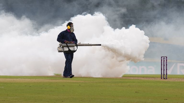 A worker fumigates the field during the Women's World Cup match between India and Pakistan in Colombo to remove flying bugs (AP)