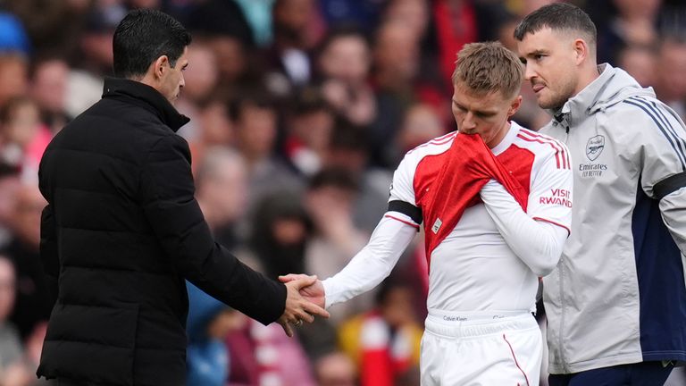 Arsenal's Martin Odegaard shakes hands with manager Mikel Arteta as he leaves the game against West Ham with an injury