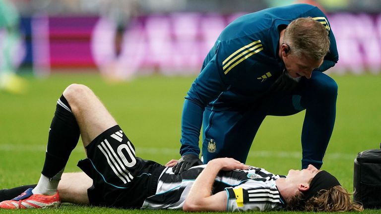 Newcastle United's Anthony Gordon is checked on by medical staff after going down injured during the UEFA Champions League match at St James