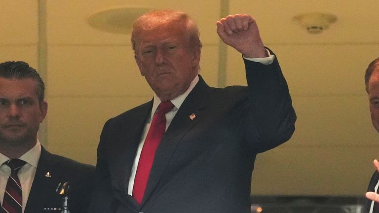 President Donald Trump gestures to the crowd at the Washington Commanders game 