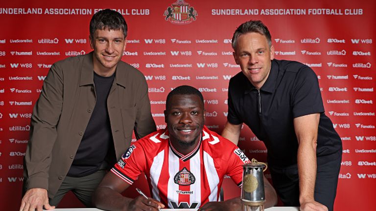 SUNDERLAND, ENGLAND - SEPTEMBER 2: Brian Bobbery poses for pictures with Director of Football Florent Ghisolfi (L) and Sporting Director Krisjaan Speakman (R) after signing a five year deal for Sunderland at The Academy of Light on September 2, 2025 in Sunderland, England.  (Photo by Ian Horrocks/Sunderland AFC via Getty Images)