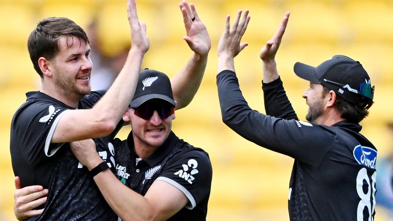 Jacob Duffy, left, Nathan Smith, and Devon Conway of New Zealand celebrate the wicket of Joe Root of England 