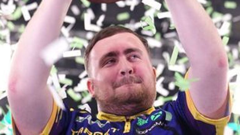 Luke Littler celebrates with the Grand Slam of Darts trophy