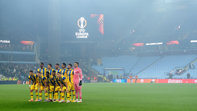 The Maccabi Tel Aviv players pose for a team photo in front of an empty away section at Villa Park