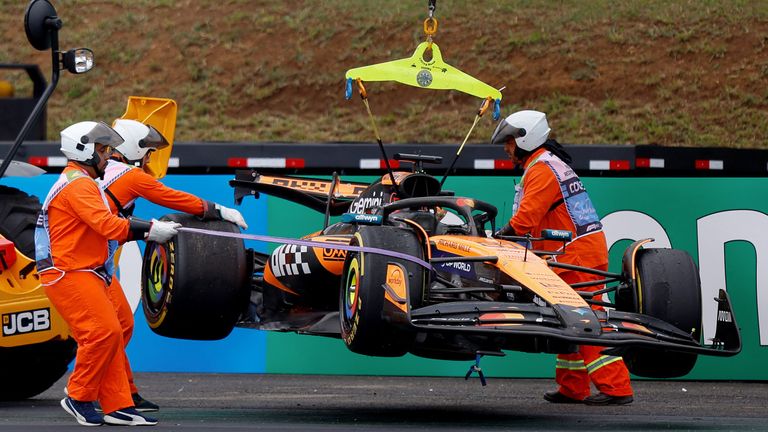 Marshals remove the car of McLaren's Australian driver Oscar Piastri after a crash during the sprint of the Sao Paulo Formula One Grand Prix at the Jose Carlos Pace racetrack, aka Interlagos, in Sao Paulo, Brazil on November 8, 2025. (Photo by Miguel SCHINCARIOL / AFP)