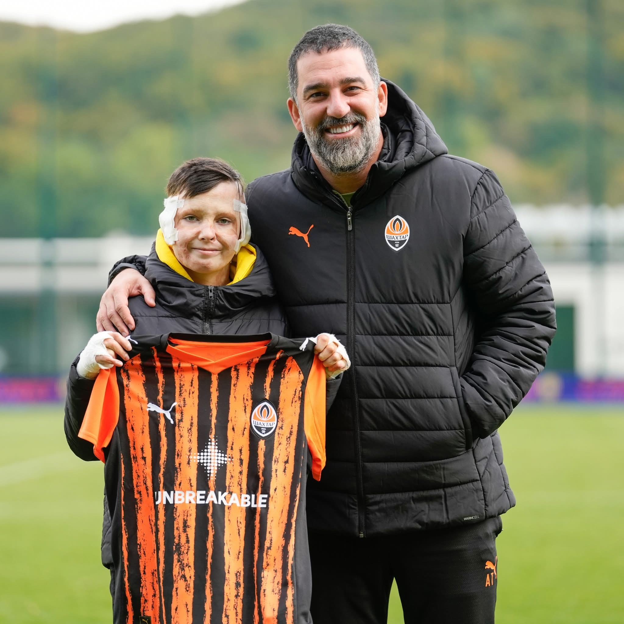 Shakhtar coach Arda Turan with young fan Roman whose house was destroyed in the bombing