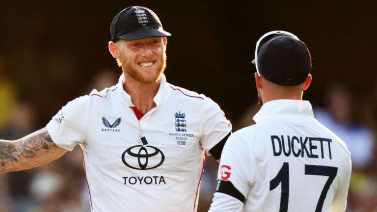 England's captain Ben Stokes celebrates with teammate Ben Duckett the wicket of Australia's Mitchell Starc during the second Ashes cricket test match between Australia and England in Brisbane, Saturday, Dec. 6, 2025.. (AP Photo/Tertius Pickard)
