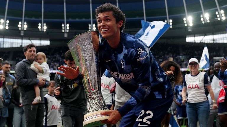 Tottenham Hotspur's Brennan Johnson with the UEFA Europa League trophy on the pitch 