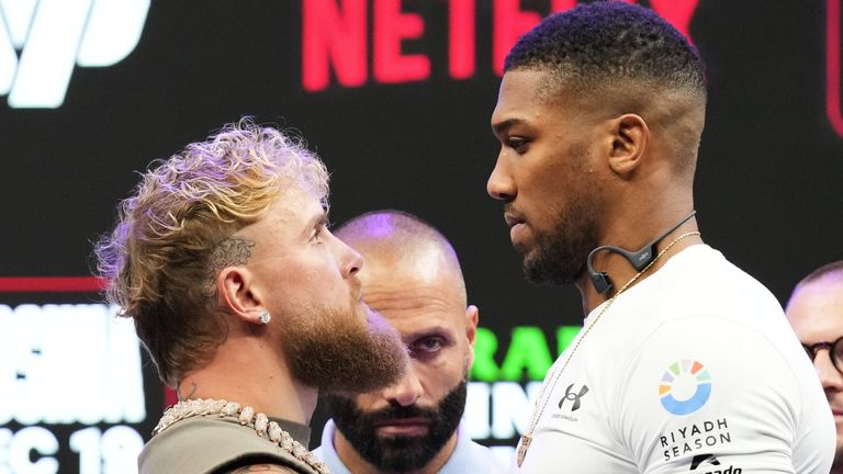 Jake Paul, left, and Anthony Joshua, right, face off during a news conference promoting their upcoming heavyweight boxing match, Friday, Nov. 21, 2025, in Miami. (AP Photo/Lynne Sladky)