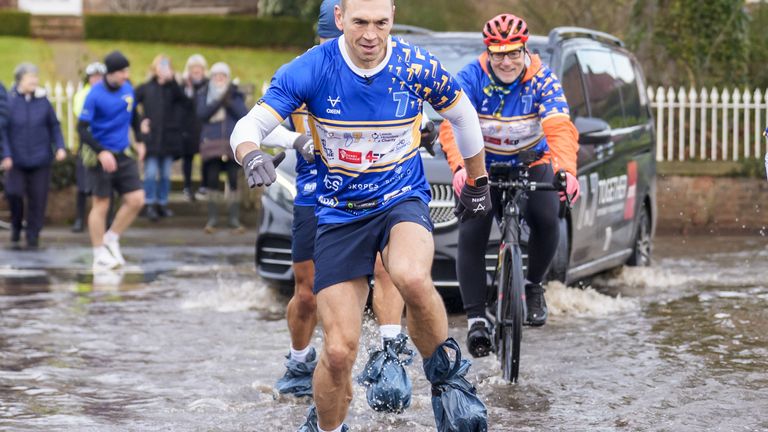 Kevin Sinfield sporting bin bags to cover his footwear as he runs through flood water in Cattal on day seven of the 7 in 7: Together 2025 