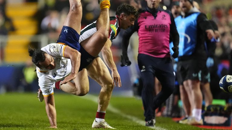Leinster Rugby's James Lowe is tackled by Leicester Tigers' Adam Radwan
