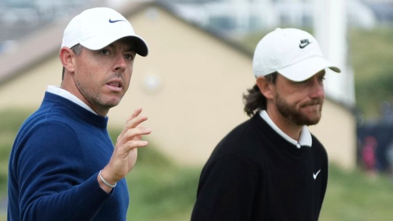 Rory McIlroy of Northern Ireland acknowledges the crowd as he walks off the 1st green with Tommy Fleetwood of England during The Open