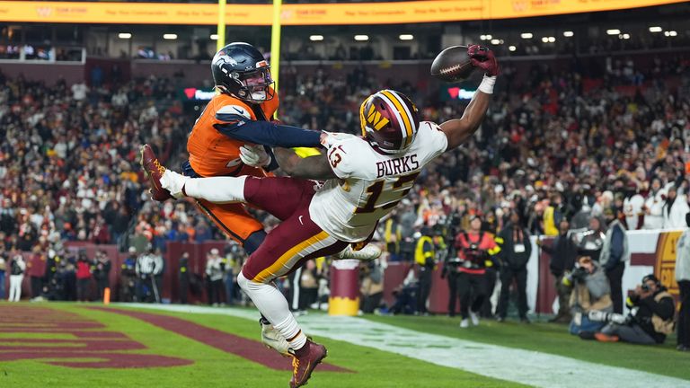 Washington Commanders wide receiver Treylon Burks (13) catches a touchdown pass as Denver Broncos cornerback Riley Moss, left, defends durin