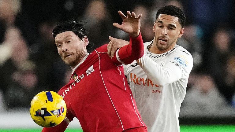 Wrexham's Kieffer Moore and Swansea City's Ben Cabango battle for the ball