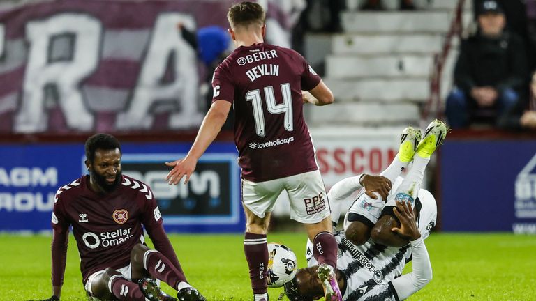 Hearts' Beni Baningime (L) looks dejected after fouling St Mirren's Roland Idowu (R) for which he is shown a red card 