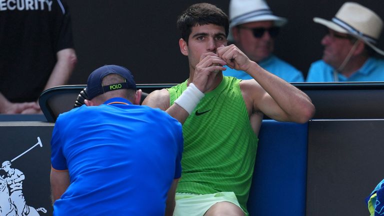 Carlos Alcaraz of Spain receives treatment during his semifinal match against Alexander Zverev of Germany at the Australian Open tennis championship in Melbourne, Australia, Friday, Jan. 30, 2026. (AP Photo/Dita Alangakra)