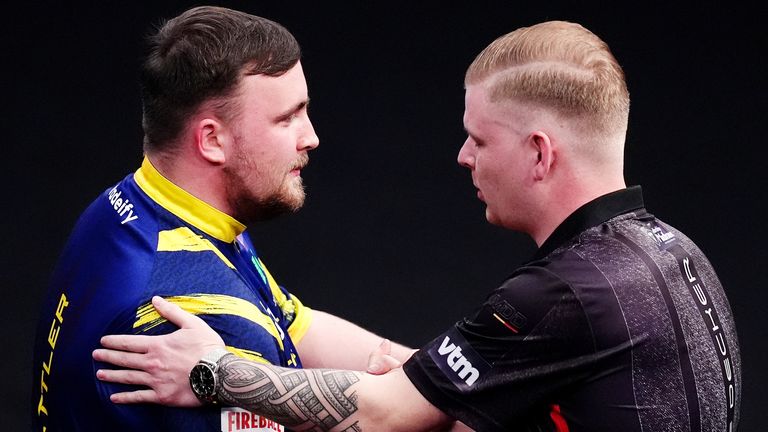 Luke Littler is congratulated by Mike De Decker after winning their first-round match at the Winmau World Masters