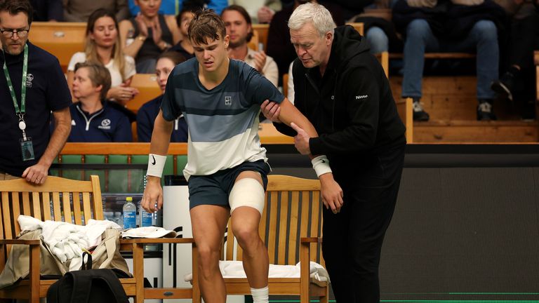 Holger Rune of Denmark is assisted off the court as he is forced to retire following an injury against Ugo Humbert of France during the Men'