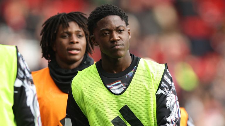 Kobbie Mainoo warms up ahead of the Manchester derby