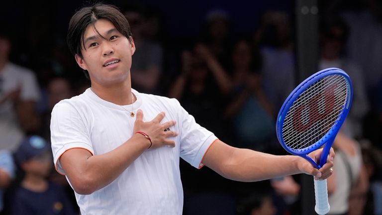 Learner Tien of the U.S. waves after defeating compatriot Marcos Giron in their first round match at the Australian Open tennis championship