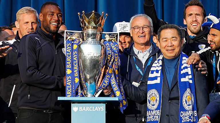 Leicester City's Thai owner and chairman Vichai Srivaddhanaprabha (3R), Leicester City's Italian manager Claudio Ranieri (C) and Leicester City's English defender Wes Morgan (2L) stand with the Premier league trophy to fans as the Leicester City team celebrate in Victoria Park, after taking part in an open-top bus parade through Leicester, to celebrate winning the Premier League title on May 16, 2016. / AFP / ADRIAN DENNIS        (Photo credit should read ADRIAN DENNIS/AFP via Getty Images)