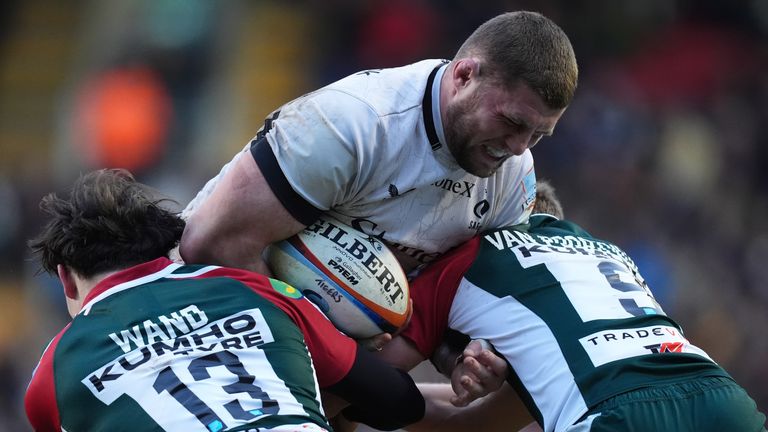 Saracens' Tom Willis is tackled by Leicester Tigers' Izaia Perese and Jack van Poortvliet