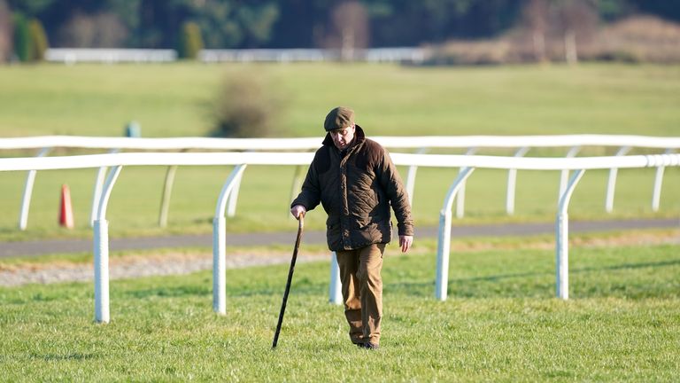 A trainer walks the course after racing is abandoned at Market Rasen Racecourse due to frozen patches