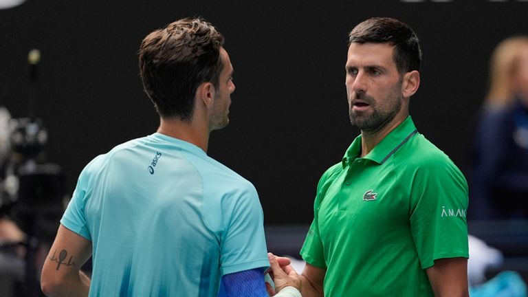 Lorenzo Musetti, left, of Italy shakes hands with Novak Djokovic of Serbia after retiring from their quarterfinal match at the Australian Open tennis championship in Melbourne, Australia, Wednesday, Jan. 28, 2026. (AP Photo/Asanka Brendon Ratnayake)