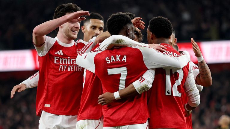 Arsenal players celebrate after taking the lead against Manchester United through a Lisandro Martinez own goal