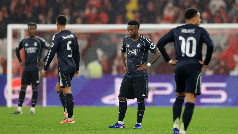 Real Madrid players stand dejected after the Champions League defeat to Benfica in Lisbon. 
