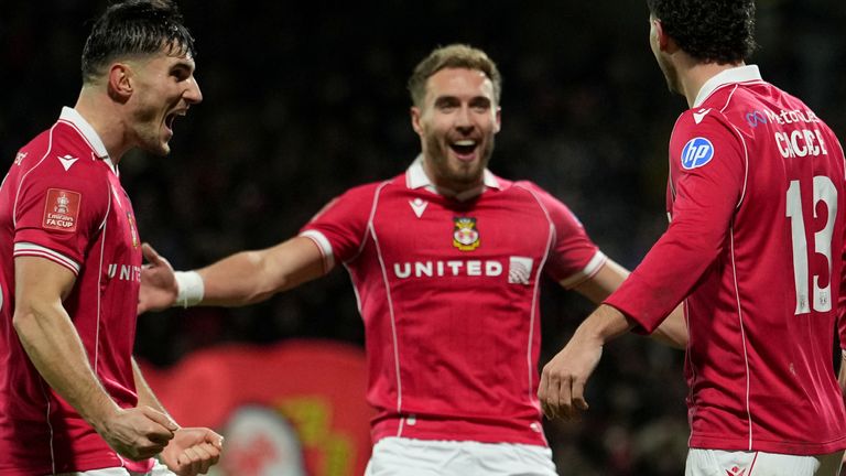 Wrexham's Liberato Cacace, right, celebrates with teammates after scoring the opening goal during the English FA Cup third round soccer match between Wrexham and Nottingham Forest in Wrexham, Wales, Friday, Jan. 9, 2026. (AP Photo/Jon Super)