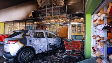 A burned-out car is seen crashed into a shop in Mexico following chaotic scenes after the death of a cartel boss. Carlos Zepeda/Getty 