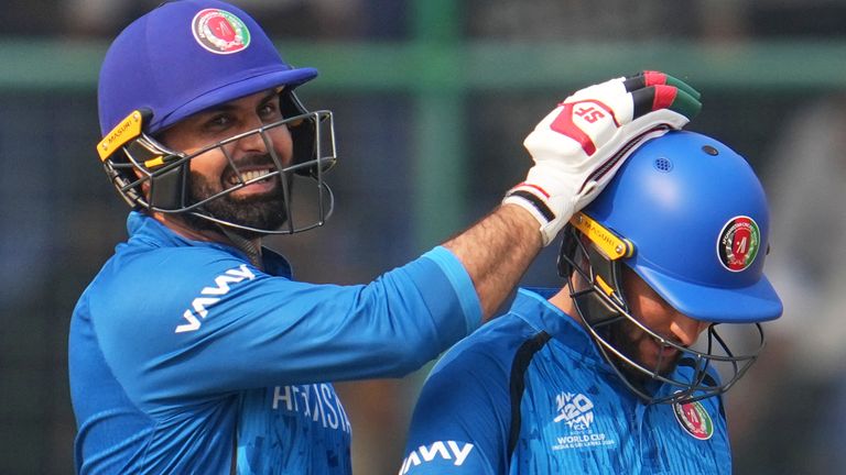 Afghanistan's Azmatullah Omarzai, right, and Mohammad Nabi celebrate after winning the T20 World Cup cricket match between Afghanistan