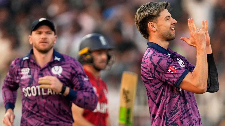 Scotland's Bradley Currie celebrates the wicket of England's Jos Buttler, back center, during the T20 World Cup 