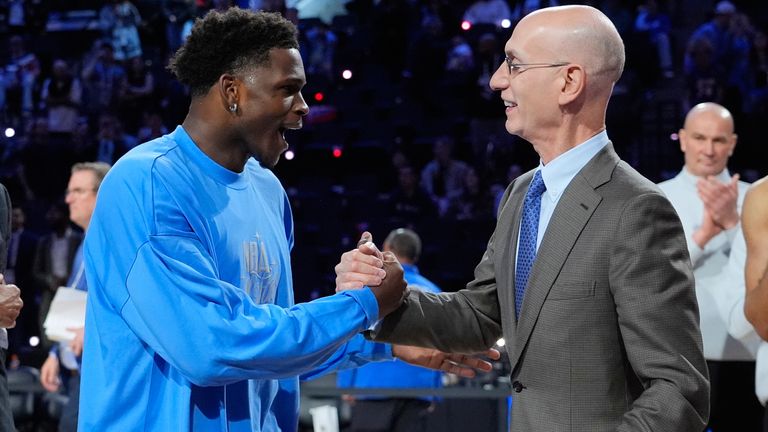 Anthony Edwards, left, shakes hands with commissioner Adam Silver after claiming his first All-Star MVP award