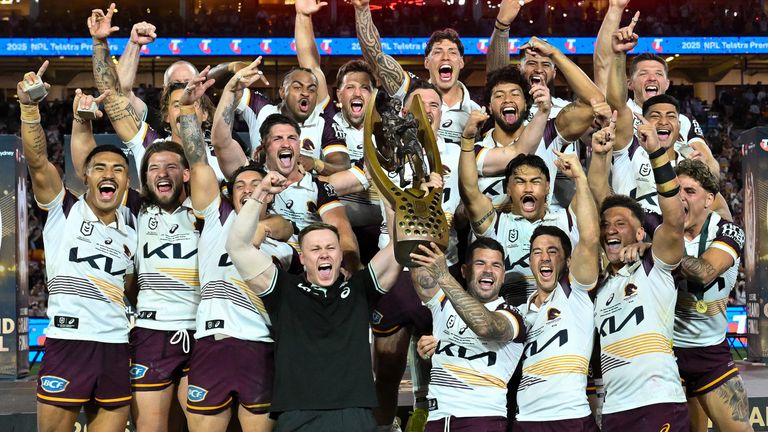 Brisbane Broncos' players celebrate with the trophy after winning the NRL Grand Final