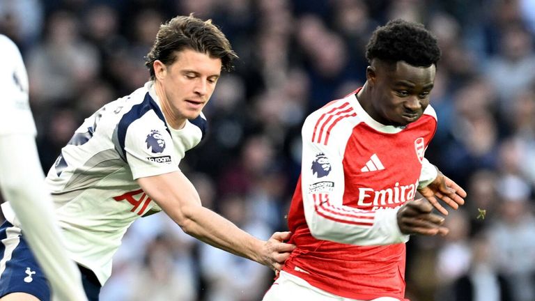 Bukayo Saka runs with the ball with Conor Gallagher in pursuit