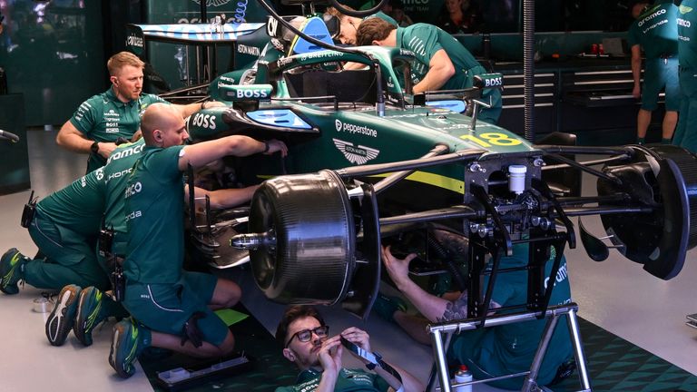 Mechanics work on the car of Aston Martin's Canadian driver Lance Stroll during the second practice session