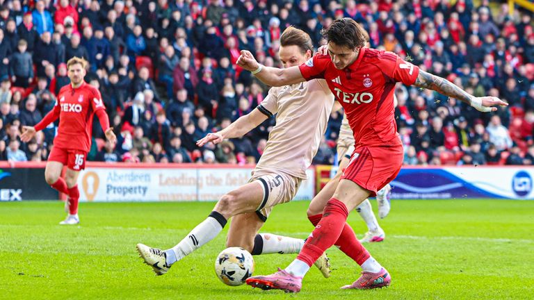 Aberdeen's Marko Lazetic has a shot under pressure from Falkirk's Liam Henderson 
