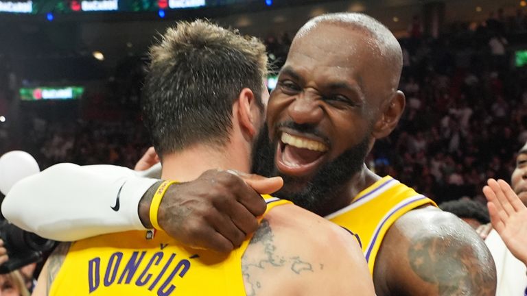 Los Angeles Lakers guard Luka Doncic (77) and forward LeBron James, right, embrace after their win over the Miami Heat