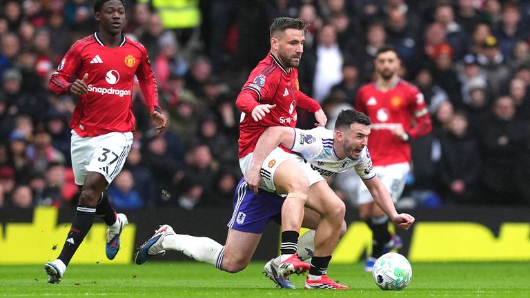 Manchester United's Luke Shaw (left) and Aston Villa's John McGinn compete for possession
