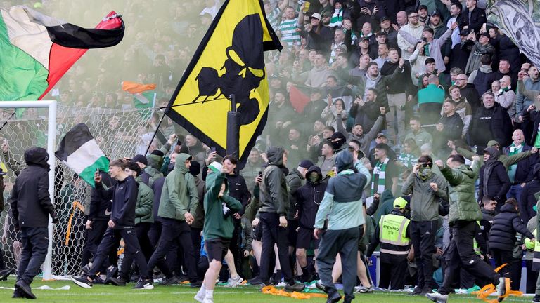 Celtic fans spill onto the pitch at Ibrox following their team's penalty shootout win against Rangers