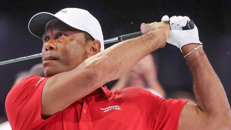 Tiger Woods hits a practice iron from a grass pad before the TGL finals golf tournament 