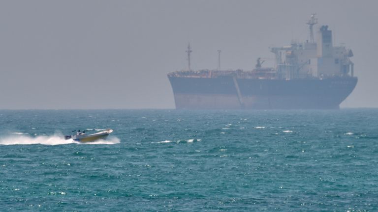 A boat sails past a tanker anchored on the Strait of Hormuz on April 18, 2026. (AP Photo/Asghar Besharati, File)