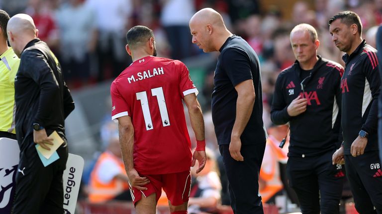 Arne Slot speaks with Mohamed Salah after the Liverpool winger leaves the game with an injury