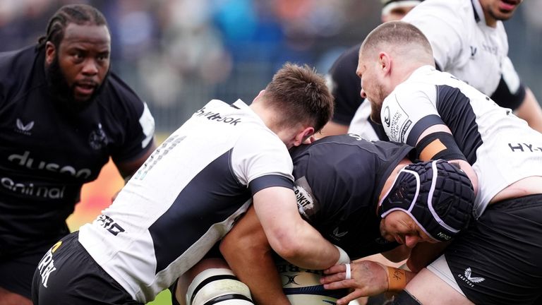 Bath's Quinn Roux is tackled by Saracens' Tobias Elliott and Tom Willis 
