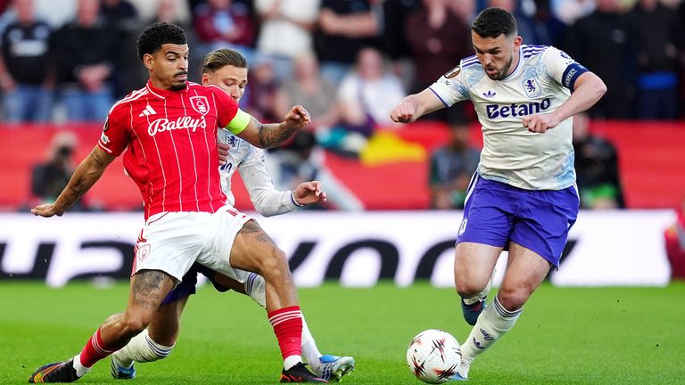 Aston Villa's John McGinn and Matty Cash battle for the ball with Nottingham Forest's Morgan Gibbs-White